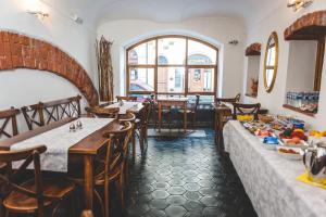 Un restaurante con mesas y sillas y un gran ventanal. en Hotel u České koruny, en Hradec Králové