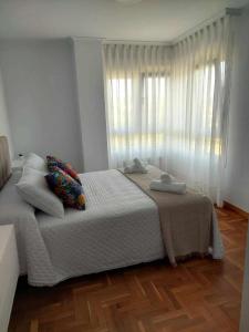 a bedroom with a large white bed and a window at La Marina Posada de LLanes VUT-3648-AS in Posada de Llanes