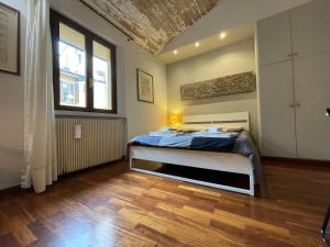 - une chambre avec un lit dans une pièce dotée de parquet dans l'établissement Giulia Suite Bologna, à Bologne