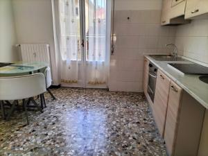 cocina con mesa, fregadero y encimera en casa gio en Novi Ligure