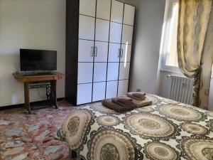 um quarto com uma cama com uma cómoda e uma televisão em casa gio em Novi Ligure