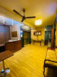 a living room with a ceiling fan and a wooden floor at Homestay Ac Dormitory in New Delhi