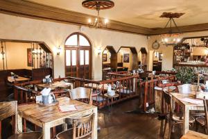 a restaurant with wooden tables and chairs in a room at Hotel U Simla in Karlovy Vary