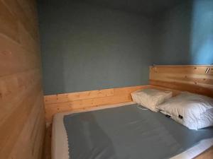 ein kleines Schlafzimmer mit einem Bett mit einem Kopfteil aus Holz in der Unterkunft Studio Montgenèvre, 1 pièce, 5 personnes - FR-1-445-62 in Montgenèvre