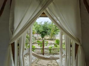 an open window with a view of a garden at KUA Cabañas in Palomino