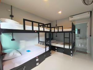 een kamer met 3 stapelbedden en een spiegel bij Blanco Beach Bar Hostel in Phi Phi Don