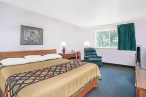 een hotelkamer met een groot bed en een stoel bij Super 8 by Wyndham Queensbury Glens Falls in Queensbury