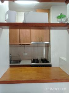 une cuisine avec des armoires en bois et un four à plaques de cuisson dans l'établissement Apartamento Illa Blanca, à Es Pujols