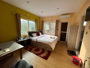 a bedroom with a bed and a large window at Hotel Village View Nagarkot in Nagarkot