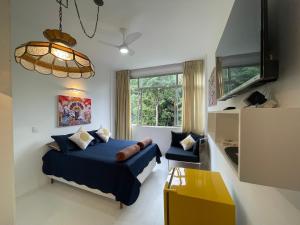 a bedroom with a blue bed and a window at STUDIO12 in Petrópolis