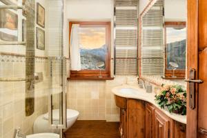 uma casa de banho com um lavatório, um WC e uma janela. em 5 min Piste Sci, Garage - Ski House Prerichard em Bardonecchia