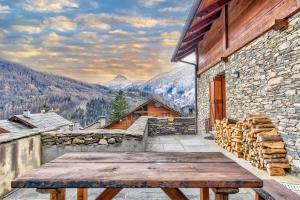 uma mesa de madeira numa varanda com vista para as montanhas em 5 min Piste Sci, Garage - Ski House Prerichard em Bardonecchia