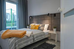 - une chambre avec un grand lit et une grande fenêtre dans l'établissement Apartament LUX 4 Cieplice, à Jelenia Góra