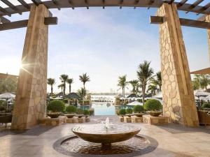 a fountain in the middle of a courtyard with palm trees at Sofitel Dubai The Palm Resort & Spa in Dubai