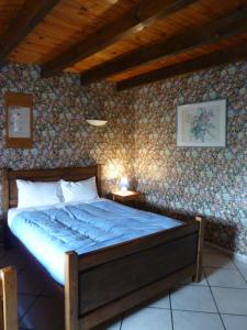 a bedroom with a bed with a blue comforter at Les Chambres De Solgne in Solgne