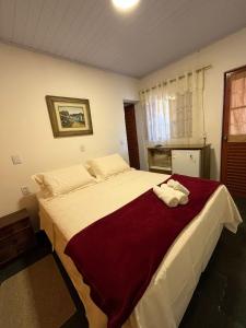 Un dormitorio con una cama grande con toallas. en Pousada Recanto das Flores, en Aiuruoca 36 fotos más