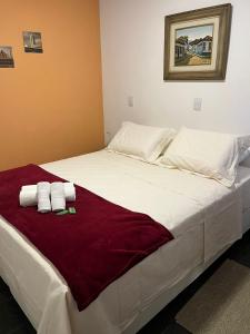 uma grande cama branca com duas toalhas em Pousada Recanto das Flores em Aiuruoca