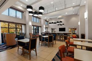 a restaurant with tables and chairs and a bar at Hampton Inn & Suites Fort Belvoir Alexandria South in Alexandria