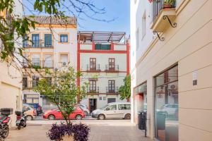 ulica miejska z samochodami zaparkowanymi przed budynkami w obiekcie Loft en Triana w Sewilli