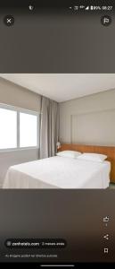 ein Schlafzimmer mit einem weißen Bett und einem Fenster in der Unterkunft Salinas Exclusive Resort in Salinópolis