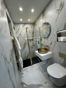 bagno bianco con lavandino e servizi igienici di Park Avenue Hotel a Londra