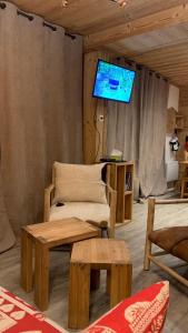 sala de estar con TV, silla y mesa en Appartement coeur de station Valfrejus 6 pers, en Modane