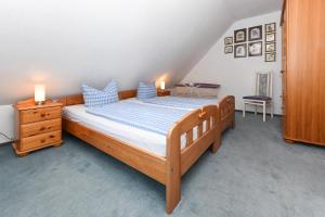 um quarto com uma cama de madeira e almofadas azuis em Ferienhaus Dat Krebs Huus em Dornumersiel