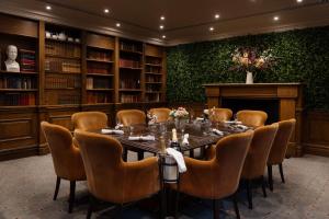 格洛斯特Hilton Puckrup Hall Hotel & Golf Club, Tewkesbury的有一张长桌和椅子的会议室