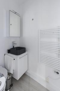 uma casa de banho branca com um lavatório e um WC em Paris - Studio - Pere-Lachaise em Paris