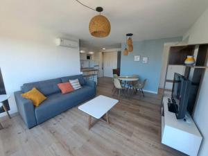 2 dormitorios, parking, ¡nuevo! في مونتيفيديو: غرفة معيشة مع أريكة زرقاء وتلفزيون