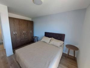 een slaapkamer met een bed en een houten kast bij 2 dormitorios, parking, ¡nuevo! in Montevideo