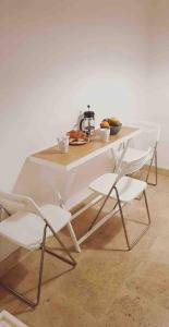 a white table with two chairs and a tea kettle at Bastille - Lappe - Quartier anime in Paris