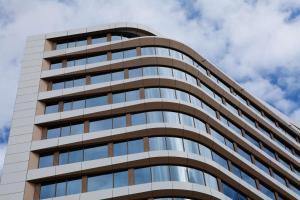 un edificio de oficinas alto con ventanas de cristal en Hampton By Hilton Munich City Center East en Múnich
