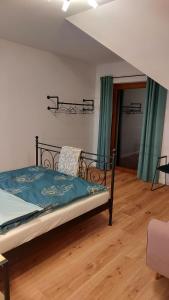 um quarto com uma cama com lençóis azuis e cortinas verdes em APARTAMENTY UL.SARNIA em Wisla