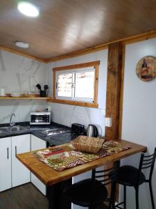 a kitchen with a table with chairs and a counter top at Tiny House Melgarejo in San Carlos de Bariloche