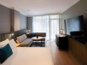 a living room with a bed and a couch at Novotel Sydney City Centre in Sydney