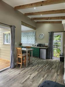 eine Küche mit einem Tisch und Stühlen im Zimmer in der Unterkunft Tsitsikamma Garden Chalets in Stormsrivier