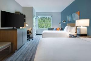 a hotel room with two beds and a flat screen tv at Hyatt House Mall Of America Msp Airport in Bloomington