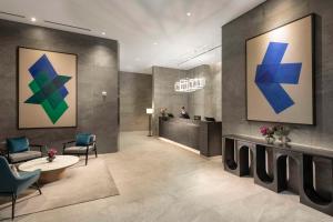 a lobby with blue and green paintings on the wall at DoubleTree By Hilton Seoul Pangyo Residences in Seongnam