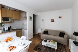 a small living room with a couch and a kitchen at Paris 15eme - Porte de versailles - Vaugirard in Paris