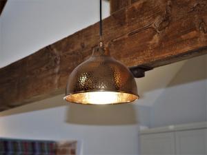 a bronze light hanging from a ceiling at Nellies Shed, Wolds Way Holiday Cottages, 3 bed spacious cottage in Cottingham