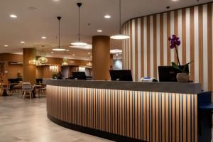 a hotel lobby with a reception desk with chairs and tables at Hampton By Hilton Budapest City Centre in Budapest