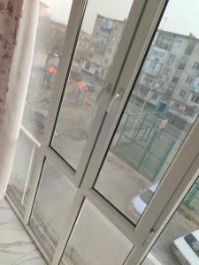 an open window with a view of a city at Элитная 2- комнатная квартира в центре города Кызылорды in Qyzylorda