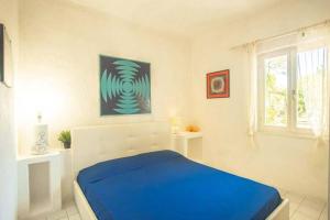 a white bedroom with a blue bed and a window at Silva in Campese