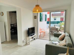 uma sala de estar com um sofá e uma televisão em Anglet - maison neuve - Proche domaine du Pignada em Anglet