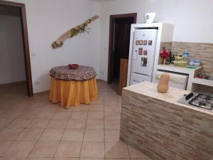 een keuken met een tafel en een koelkast bij Casa a Silius R5130 in Silìus