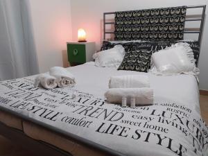 een bed met zwarte en witte lakens en handdoeken erop bij Casa a Silius R5130 in Silìus