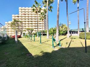 un parc avec des palmiers et un grand bâtiment dans l'établissement Studio with breakfast included and heated pool, à Los Realejos