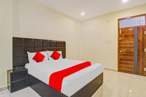 um quarto com uma cama grande e almofadas vermelhas em Lakshmi Royal Inn em Warangal