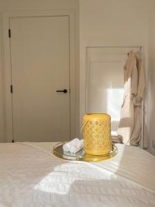 una candela gialla su un vassoio su un letto di Manchester City luxury hideaway a Urmston